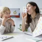 woman doing speech therapy with 2 85x85